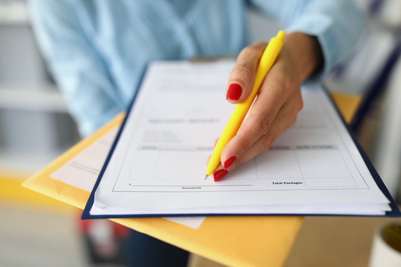 Female Hands Hold a Package and Delivery Document
